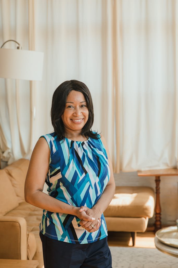 Fashionable woman smiling indoors in a stylish home setting with a cozy atmosphere.